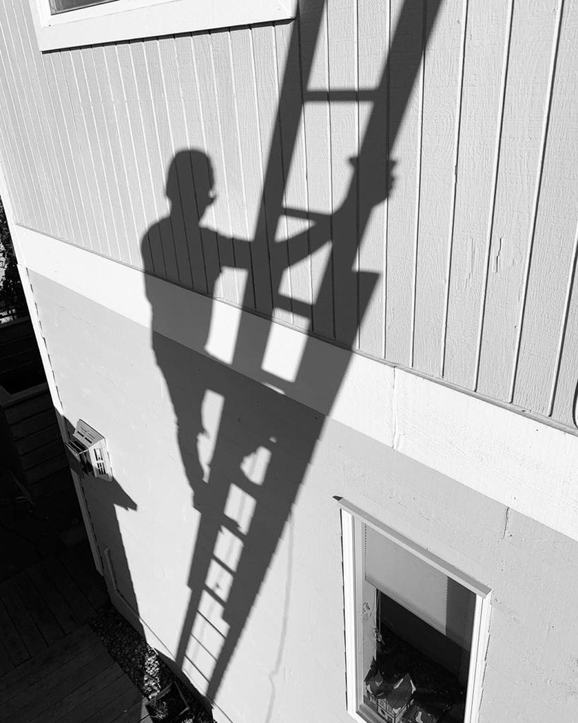 Shadow climbing up a ladder